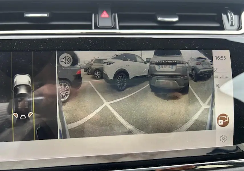 Vue écran caméra de recul montrant un Range Rover Evoque gris foncé de dos dans un parking.