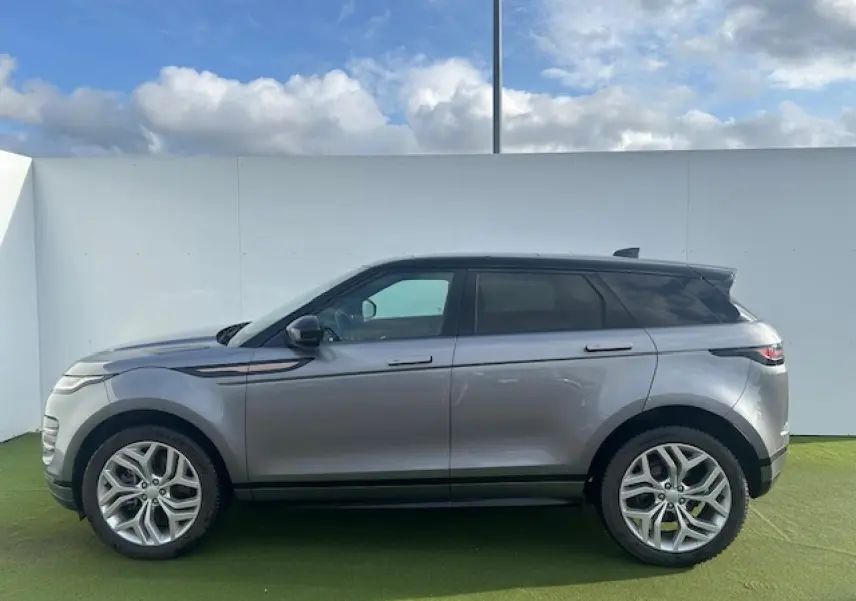 Profil droit d'un Range Rover Evoque gris foncé avec toit noir et jantes 20 pouces sur fond extérieur clair.