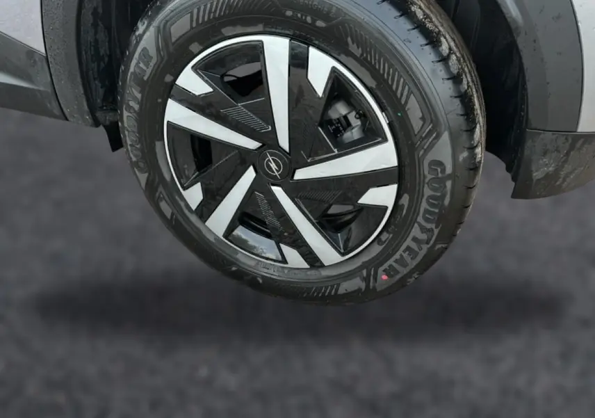 Gros plan sur la roue avant droite grise de l’Opel Mokka 2025 avec jante noire et argentée au design géométrique.