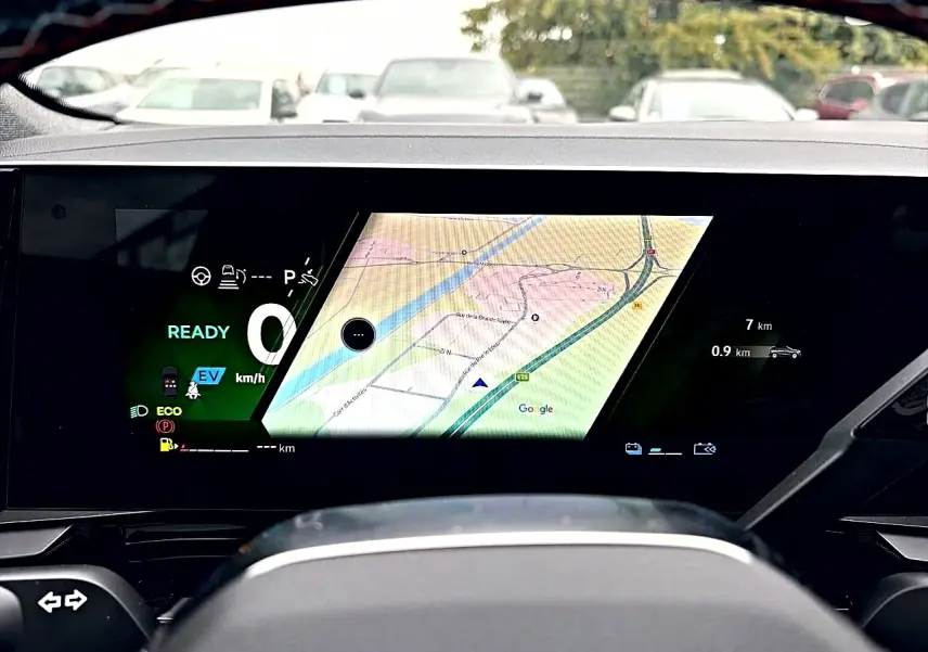 Vue intérieure du tableau de bord numérique du Renault Austral gris schiste, affichant la navigation GPS et les informations de conduite.