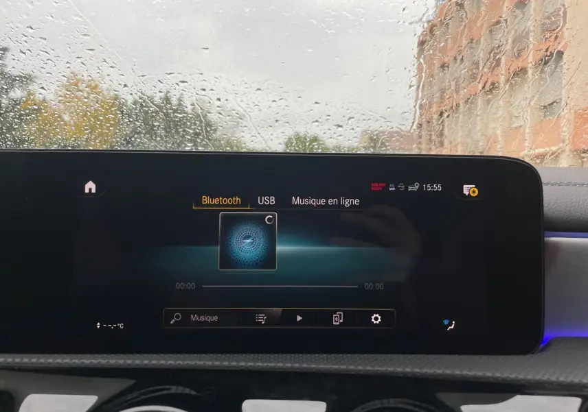 Écran tactile central de la Mercedes CLA Shooting Brake blanc 2021 affichant le menu Bluetooth sous la pluie.