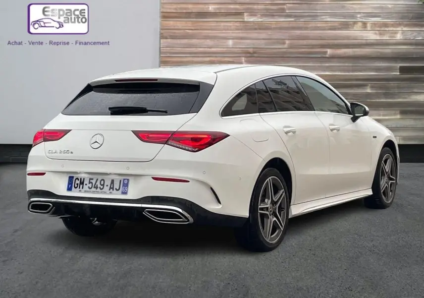 Vue 3/4 arrière droite d'une Mercedes Classe CLA Shooting Brake blanche avec jantes AMG et feux arrière LED distinctifs.