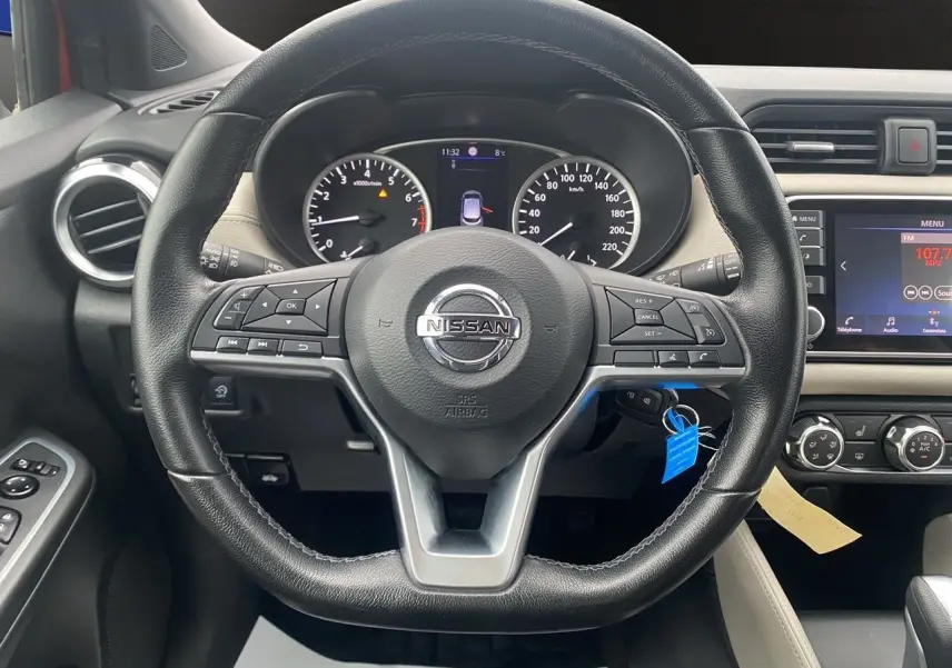 Vue rapprochée du volant noir de la Nissan Micra 2022 avec tableau de bord et écran central visible.