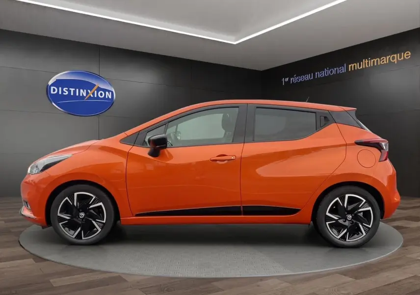 Vue latérale droite d'une Nissan Micra 2022 orange Energy avec jantes noires et détails noirs sur les bas de caisse.