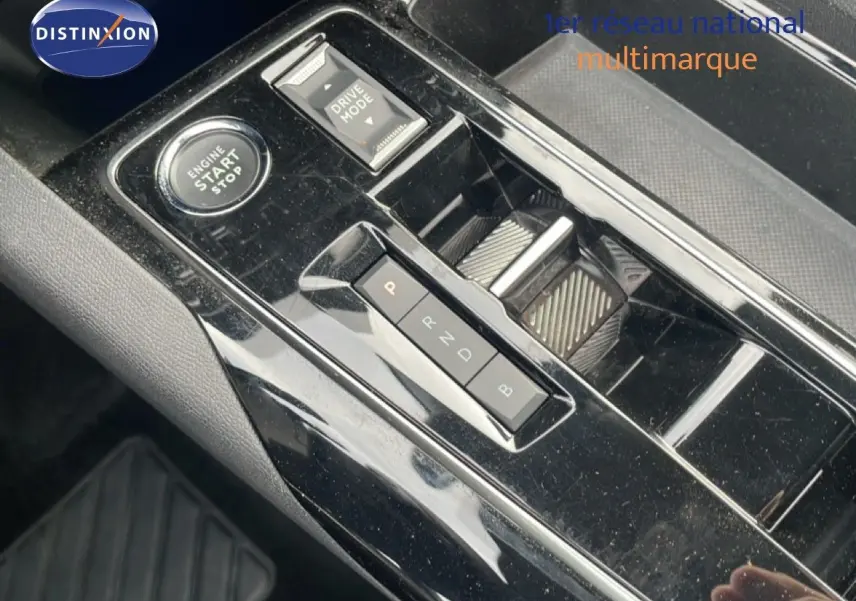 Gros plan sur la console centrale noire brillante du Peugeot 3008 2024, montrant le bouton start/stop et la commande de boîte auto.