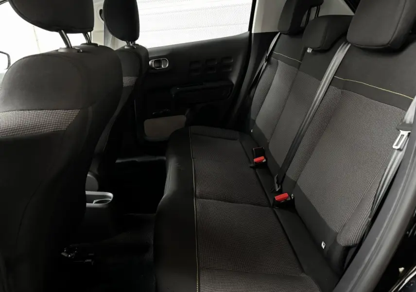 Vue intérieure arrière côté droit de la banquette noire avec ceintures et appuie-têtes du Citroën C3 2024 PureTech Shine.