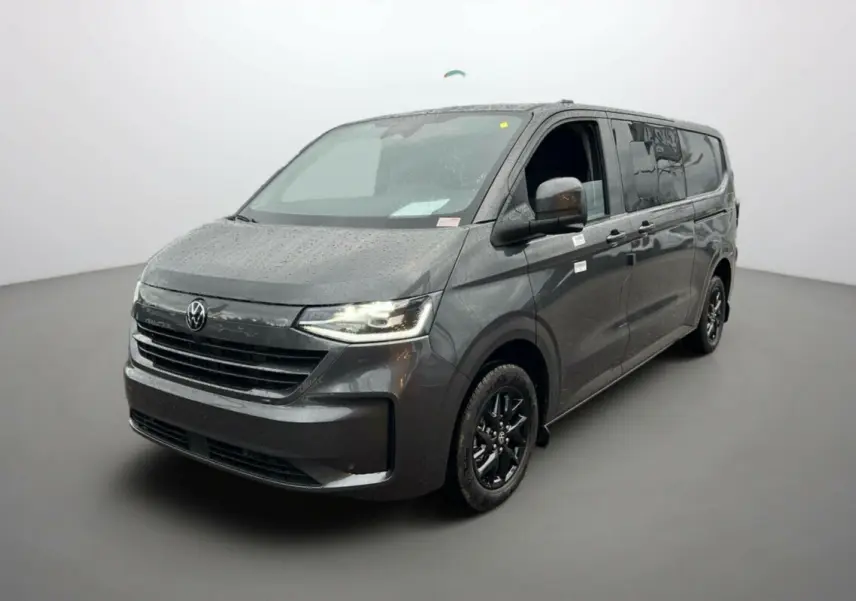 Vue 3/4 avant droite d’un Volkswagen Transporter TDI 170 DSG ProCab L2 gris graphite avec jantes alu noires et feux LED allumés.