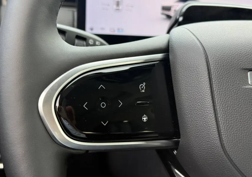 Gros plan sur les commandes multifonctions à gauche du volant noir du JAECOO J7 blanc, version 2026.