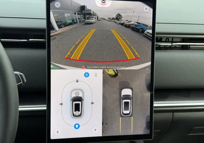 Écran tactile intérieur montrant la caméra de recul et vue 360° du JAECOO J7 blanc en stationnement.