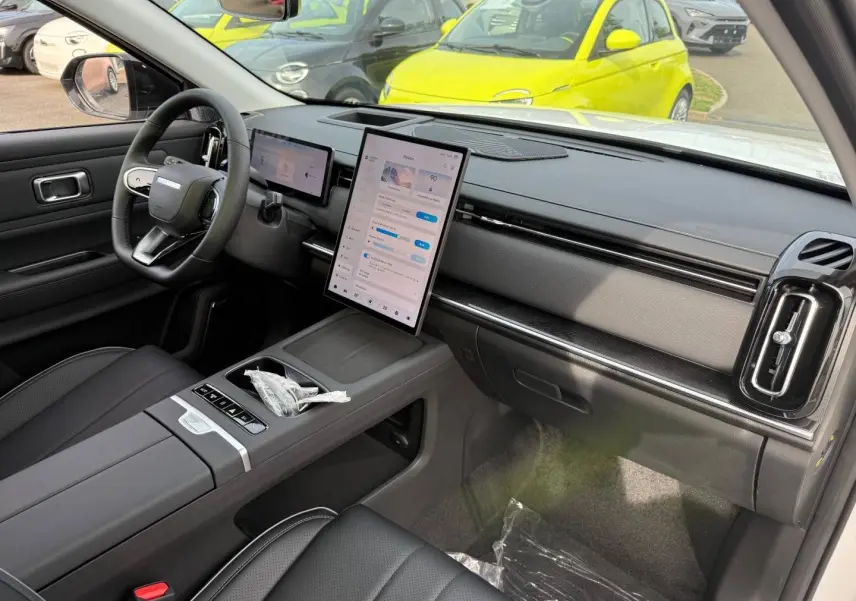 Vue intérieure côté passager du tableau de bord et console centrale du JAECOO J7 blanc avec écran tactile vertical.