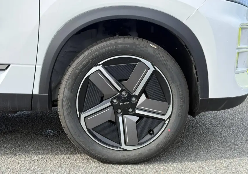 Gros plan sur la roue avant gauche de la JAECOO J7 blanche avec jante alu au design moderne.