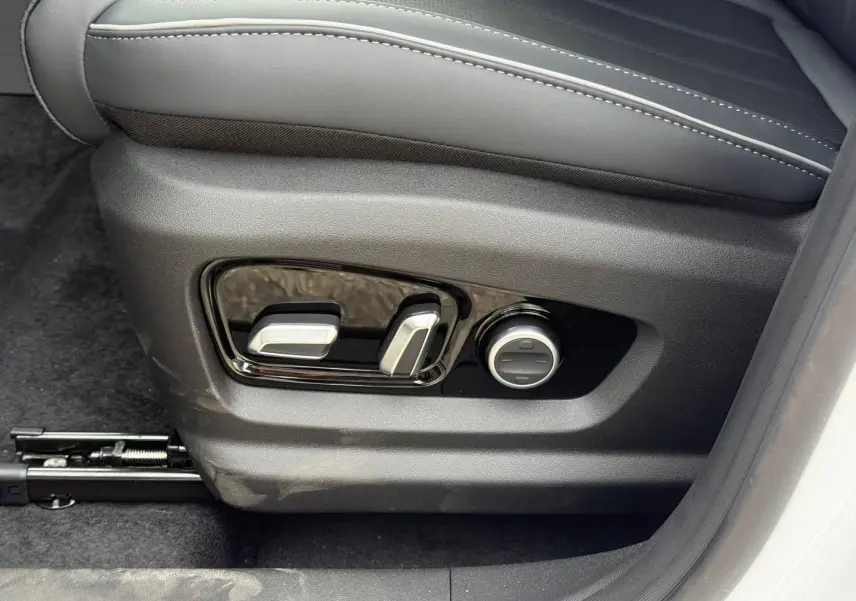 Réglages électriques du siège conducteur en similicuir noir dans le JAECOO J7 blanc, vue côté gauche.