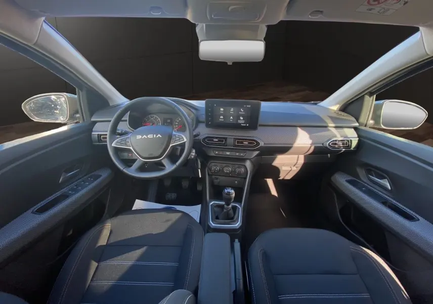 Vue intérieure avant de la Dacia Sandero Stepway 2025, tableau de bord noir avec écran tactile Media Nav et volant multifonction.