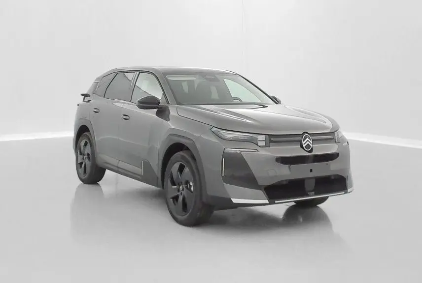 Vue 3/4 avant d'un Citroën C5 Aircross hybride gris platinium avec jantes noires et signature lumineuse LED distinctive.