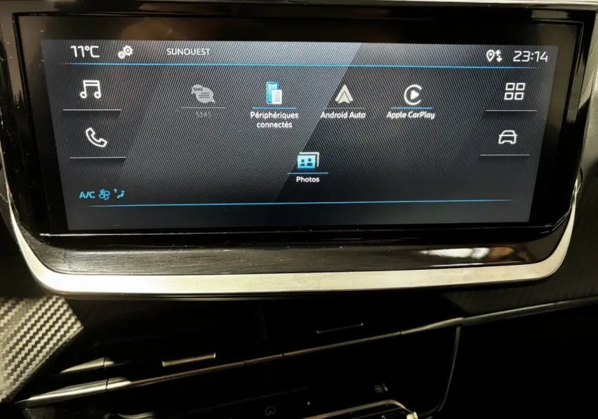 Écran tactile central de 7 pouces du tableau de bord du Peugeot 208 PureTech 100 S&S Active 2024, ambiance intérieure sombre.