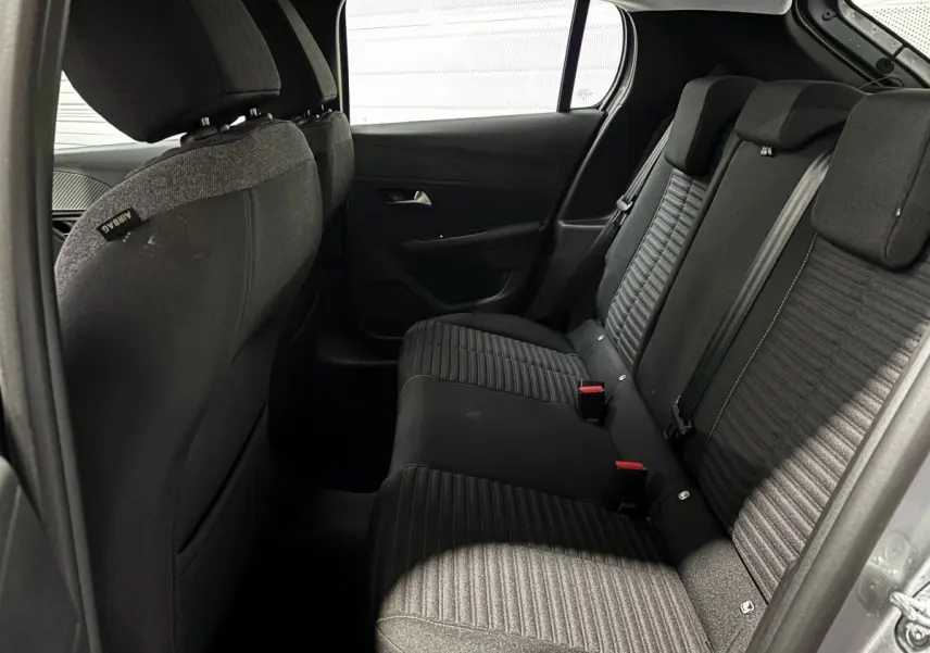 Vue intérieure du côté arrière droit de la banquette arrière noire et grise du Peugeot 208 PureTech 100 S&S Active 2024.