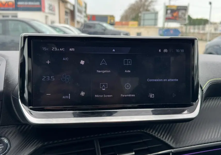 Écran tactile central du tableau de bord de la Peugeot 208 gris, affichant les options de navigation et climatisation.