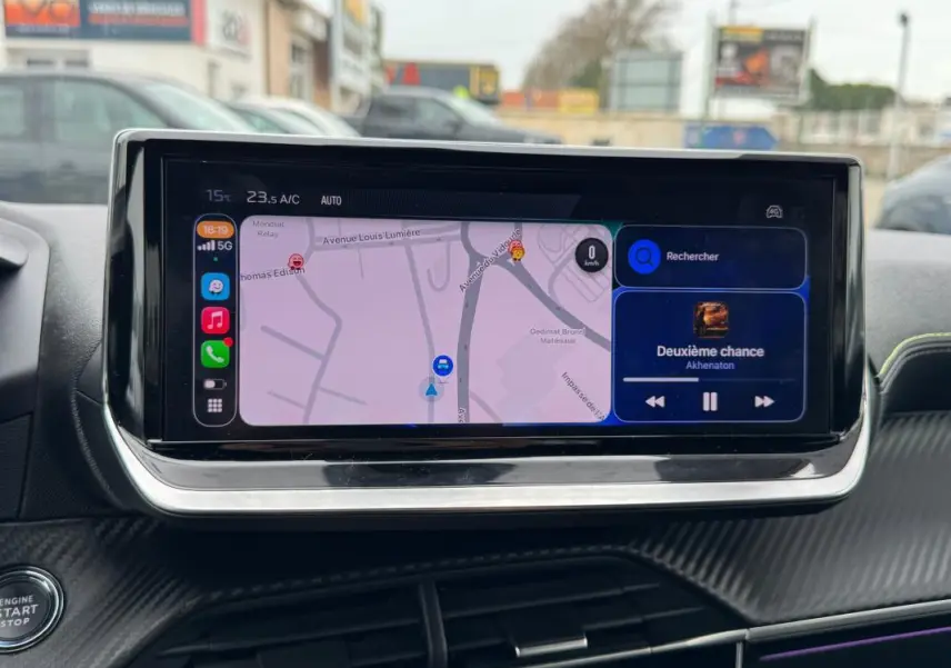 Écran tactile central de la Peugeot 208 gris, affichant navigation et musique, vue intérieure frontale rapprochée.