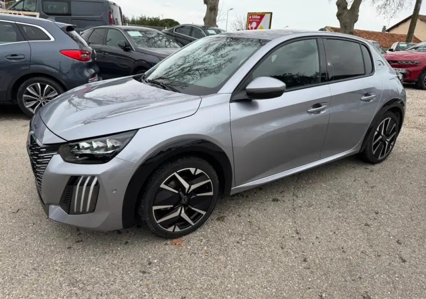 Peugeot 208 Hybrid gris vue 3/4 avant droit, jantes alliage 17 pouces et calandre distinctive en extérieur.