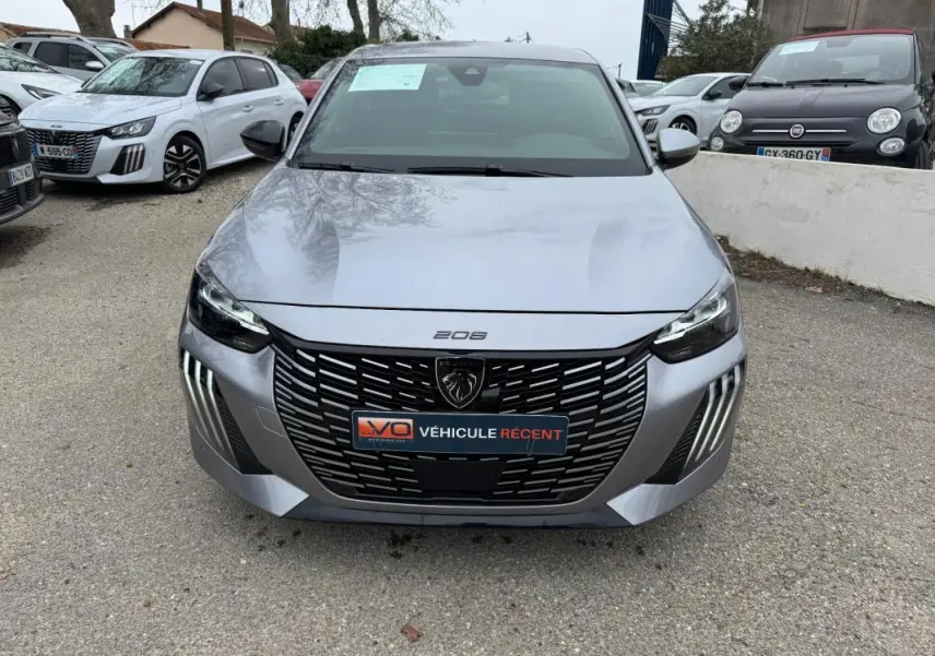 Vue avant frontale d'une Peugeot 208 Hybrid 110 gris avec calandre noire et feux LED distinctifs.