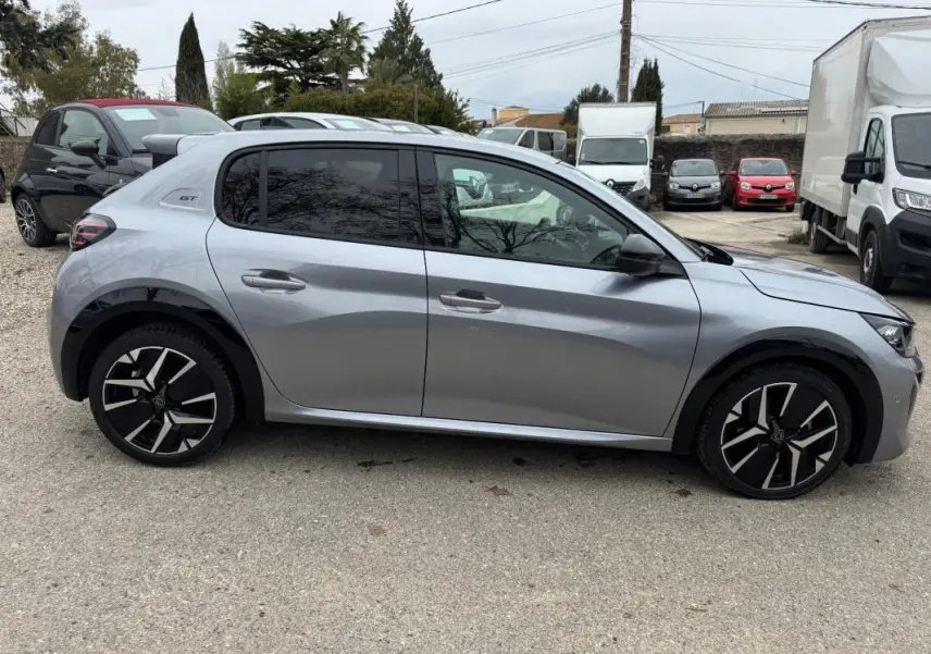 Profil droit d'une Peugeot 208 Hybrid 110 e-DCS6 GT gris avec jantes alliage 17 pouces et vitres teintées.