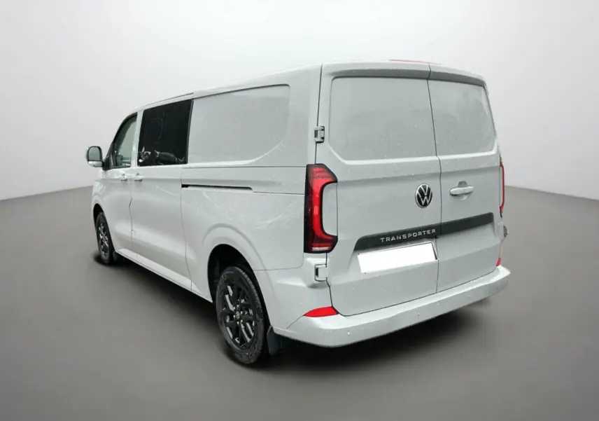 Vue 3/4 arrière droite d’un Volkswagen Transporter Stone Grey avec jantes alu noires et vitres teintées.