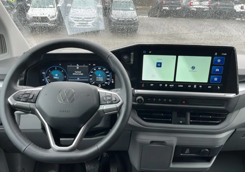 Vue intérieure du tableau de bord du Volkswagen Transporter TDI 170 DSG ProCab L2 2026 avec volant multifonctions et écran tactile large.