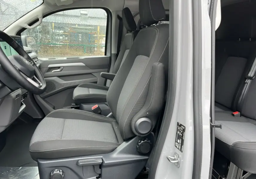 Vue latérale intérieure côté gauche du Volkswagen Transporter Stone Grey 2026, montrant les sièges avant et arrière en tissu gris.