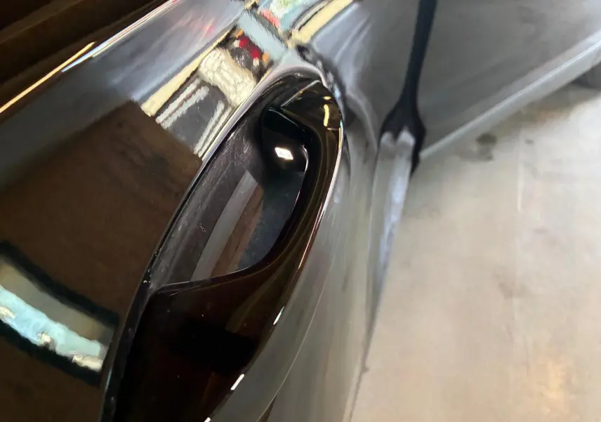 Poignée de porte noire grenadilla métal en gros plan sur un Volkswagen Tiguan 2026, vue côté gauche.