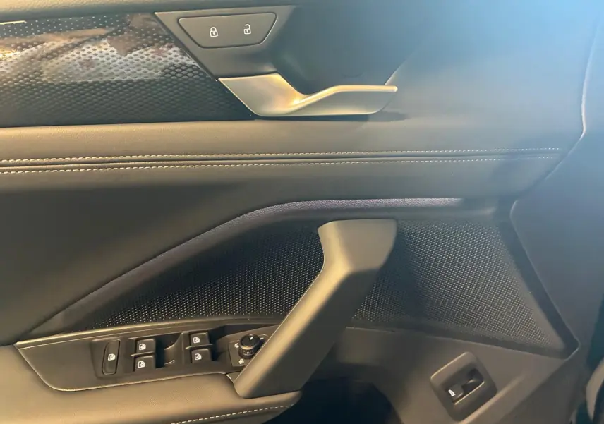 Détail de la porte côté conducteur du Volkswagen Tiguan 2026 noir Grenadilla avec commandes de vitres et verrouillage.