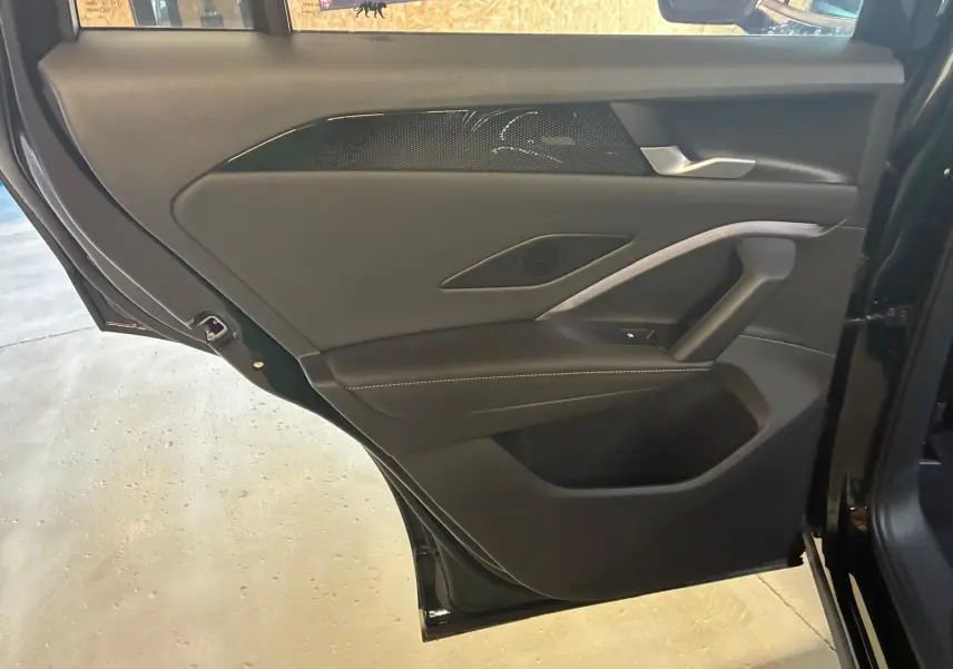 Vue rapprochée de la porte arrière gauche noire Grenadilla métal du Volkswagen Tiguan 2026 avec garniture intérieure noire.