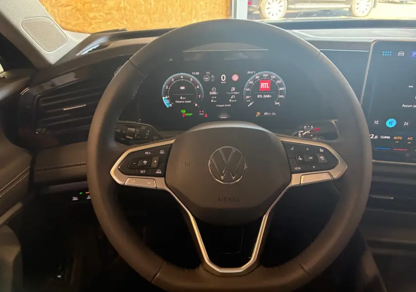 Vue intérieure centrée sur le volant multifonction du Volkswagen Tiguan 2026 avec tableau de bord numérique allumé.