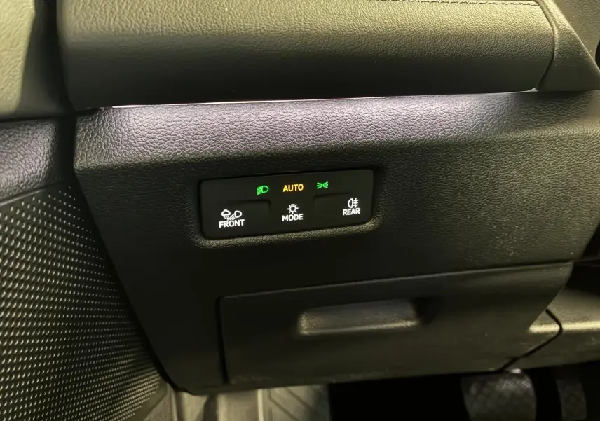 Gros plan sur les commandes d’éclairage automatiques du tableau de bord noir du Volkswagen Tiguan 1.5 TSI 130 DSG Life 30 Years.