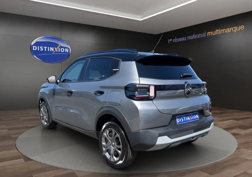 Vue 3/4 arrière droite d'une Citroën C3 hybride gris foncé avec toit noir et feux arrière LED distinctifs.