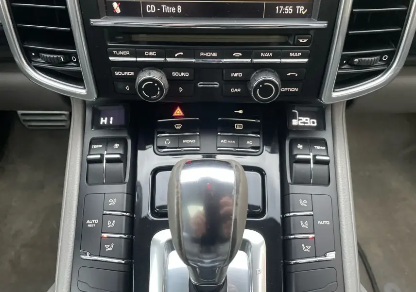 Vue rapprochée de la console centrale grise du Porsche Cayenne S Hybrid 2010 avec levier de vitesses automatique et commandes climatisation.