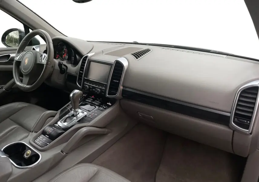 Intérieur gris du Porsche Cayenne S Hybrid 2010 vu côté passager, avec tableau de bord et console centrale élégants.