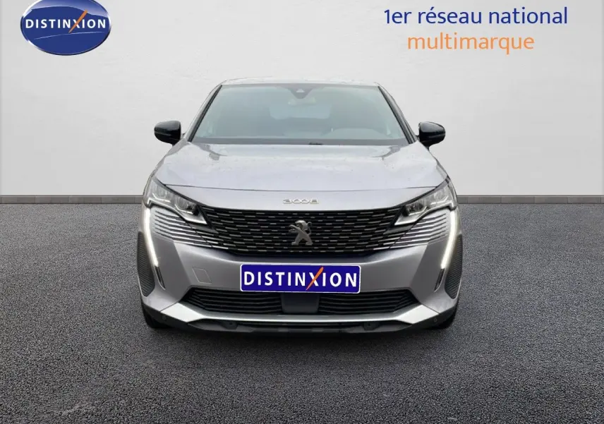 Vue frontale d'un Peugeot 3008 gris Artense métal 2024 avec calandre noire et feux LED verticaux allumés.