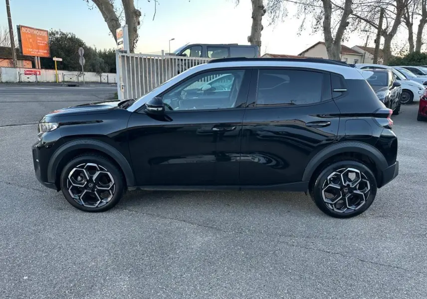 Profil côté gauche d'une Citroën C3 noire 2025 avec jantes alliage 17 pouces et barres de toit visibles.