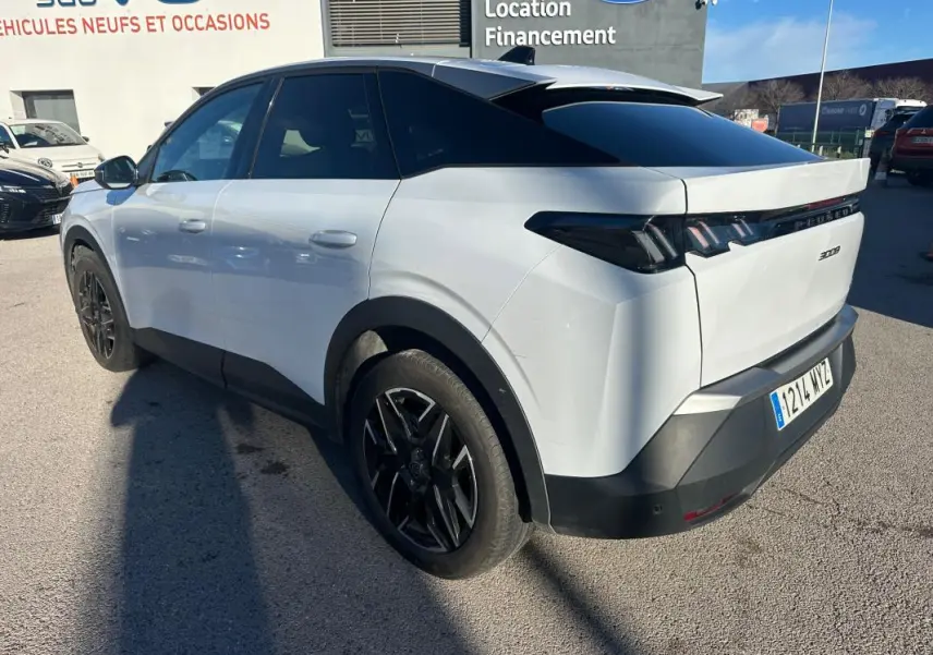 Vue 3/4 arrière droite d’un Peugeot 3008 Hybrid blanc avec jantes alliage noires de 19 pouces, toit noir et vitres teintées.