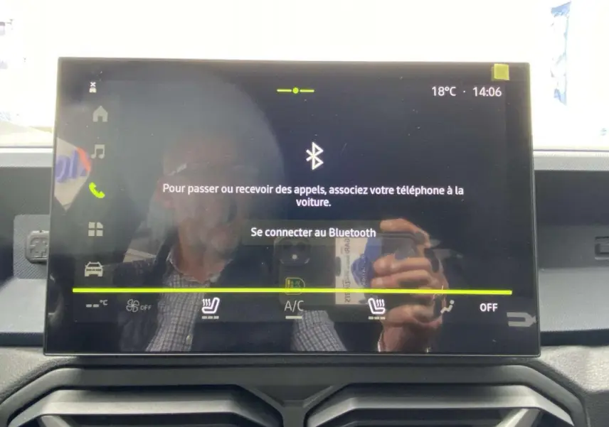Écran tactile central du Dacia Duster 2025 affichant la connexion Bluetooth, avec commandes climatisation visibles en dessous.