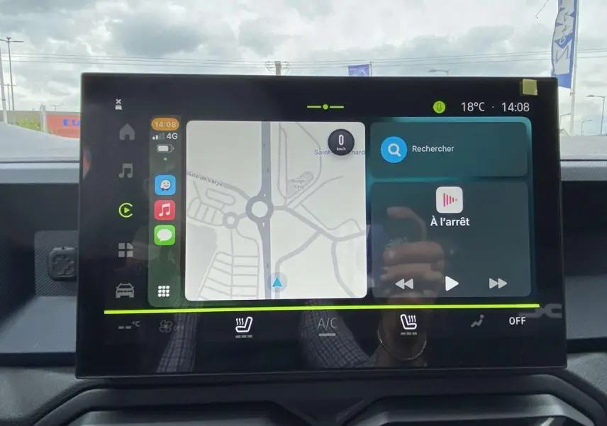 Écran tactile central du Dacia Duster 2025 affichant la navigation et les commandes de climatisation, intérieur noir.