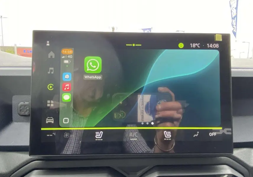Écran tactile central du tableau de bord du Dacia Duster 2025, affichant l’interface multimédia avec WhatsApp.