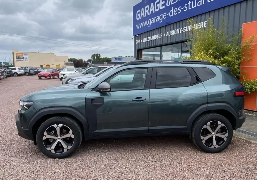 Vue de profil côté gauche du Dacia Duster 1.6 Hybrid 2025 en vert INC avec jantes alliage et détails noirs contrastants.