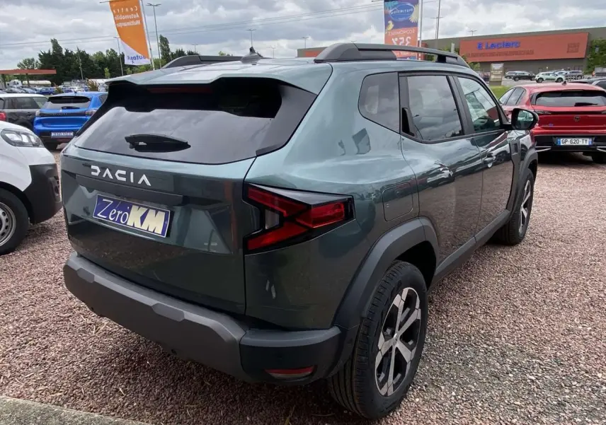 Vue 3/4 arrière droite du Dacia Duster 1.6 Hybrid 2025 en couleur INC avec jantes alliage et toit noir.