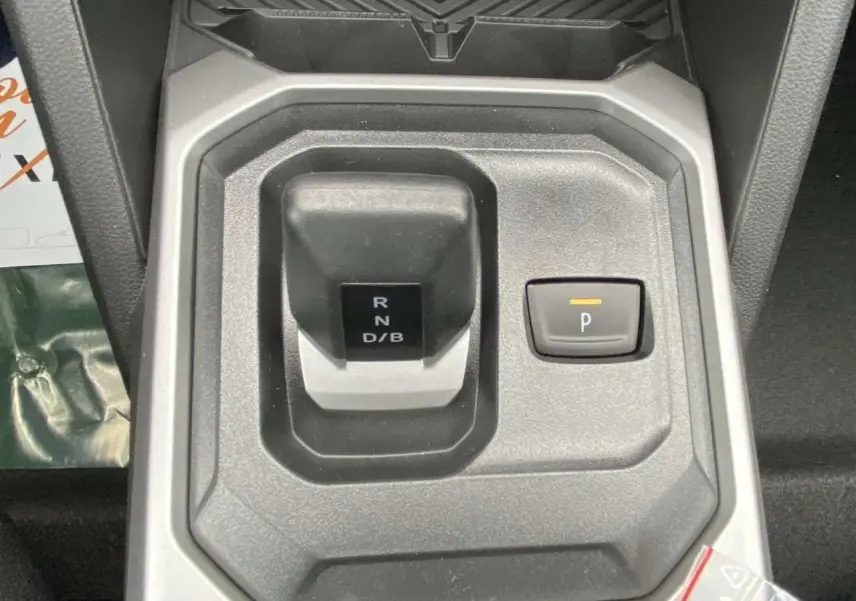 Vue rapprochée du levier de vitesses automatique gris et noir du Dacia Duster 1.6 Hybrid 2025 avec bouton de parking activé.