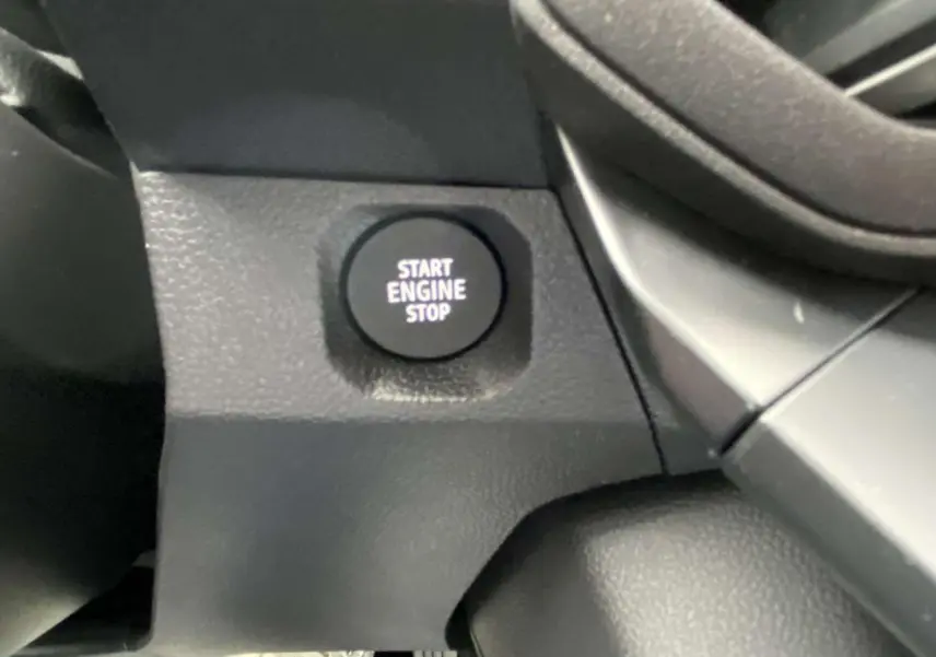 Détail intérieur du bouton Start Engine Stop sur le tableau de bord du Dacia Duster 2025, finition noire.