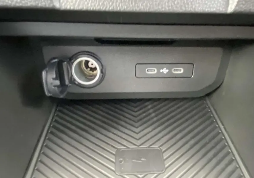 Prise allume-cigare et double port USB-C dans le rangement central du Dacia Duster 1.6 Hybrid 2025.