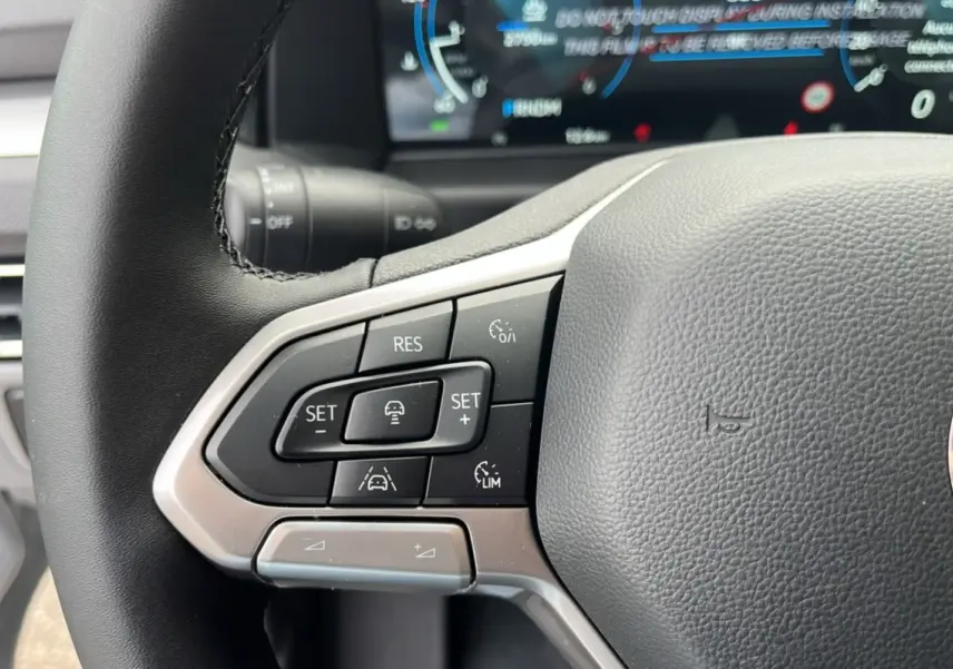 Gros plan sur le volant multifonctions noir du Volkswagen Transporter TDI 170 DSG 2026 avec commandes de régulateur adaptatif.
