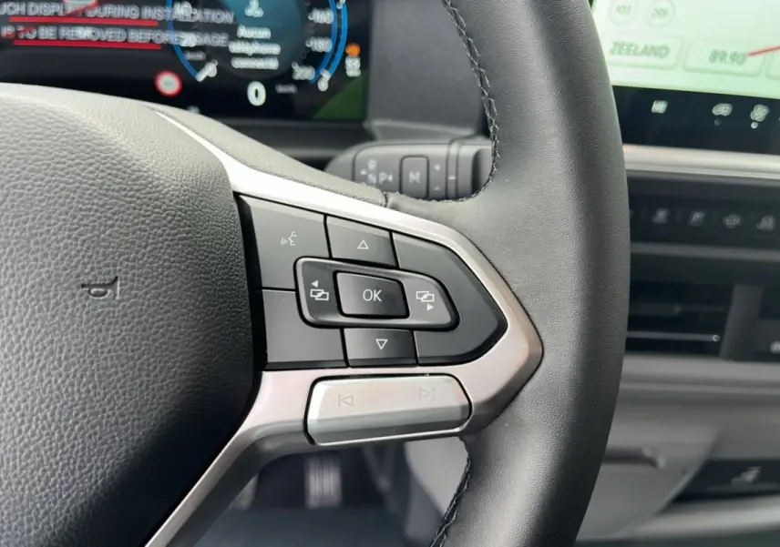 Gros plan sur le volant multifonctions noir du Volkswagen Transporter TDI 170 DSG ProCab L1 2026 avec tableau de bord numérique.