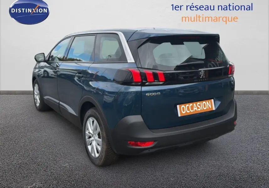 Vue 3/4 arrière droite d'un Peugeot 5008 bleu Célèbes métal avec feux arrière à griffes et toit contrasté gris clair.